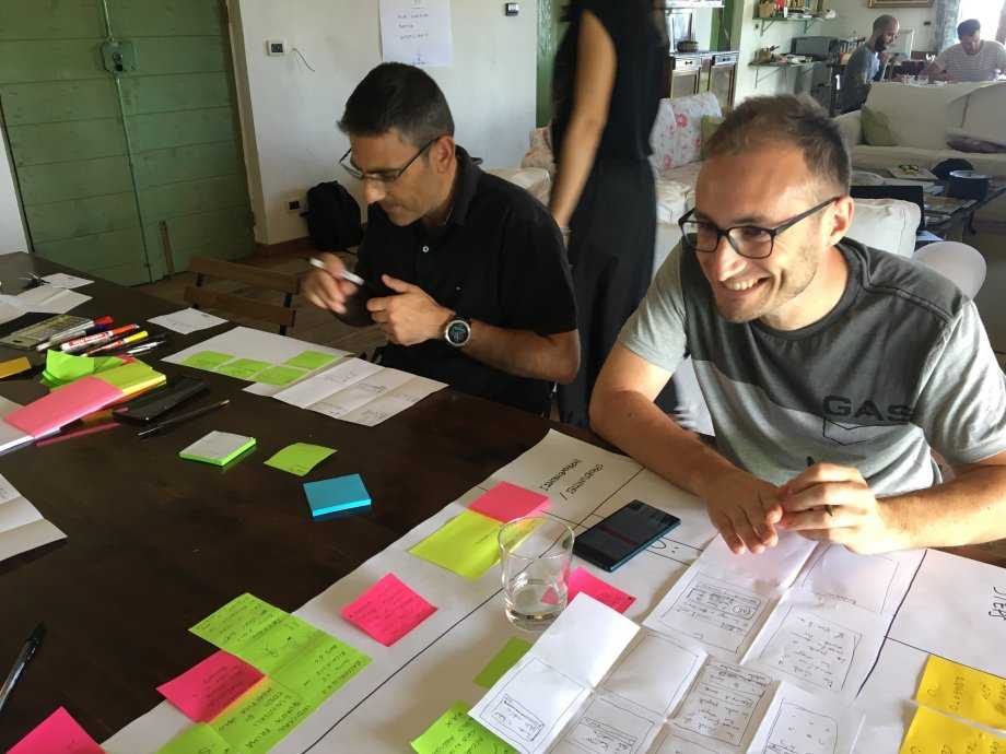 The team around a table covered in sticky notes and sketches during the two-day design sprint